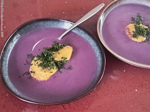 Zwei Teller mit Rotkohlsuppe mit Grießklößen