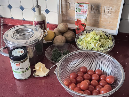 Zutaten auf Arbeitsfäche für Eintopf mit Kichererbsen, Kartoffeln und Tomaten