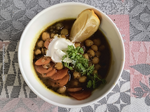 Bowl Karotten- und Kichererbsen-Tajine mit Joghurt und Zitronenspalte