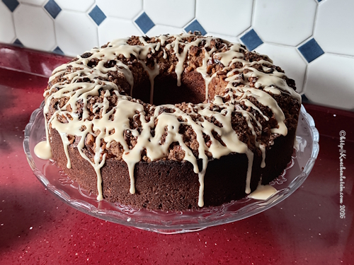 Mit Glasur verzierter Sauerrahm Kaffeekuchen auf einer Tortenplatte mit Fuß