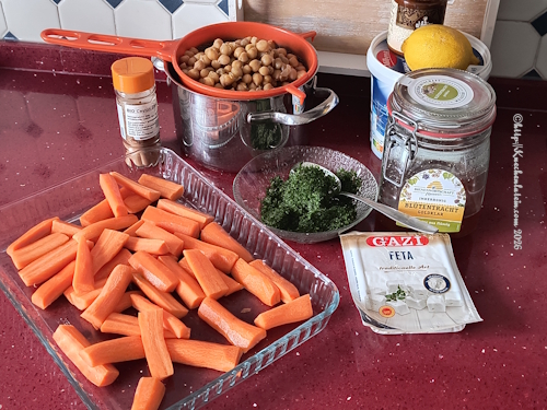 Einzelzutaten auf Arbeitsfläche für Honig-Harissa-Karotten mit Kichererbsen auf Feta-Joghurtcreme